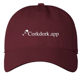 Image of a dark red/burgundy color baseball cap/dad hat with the Corkdork tilted wine glass icon and the word 
